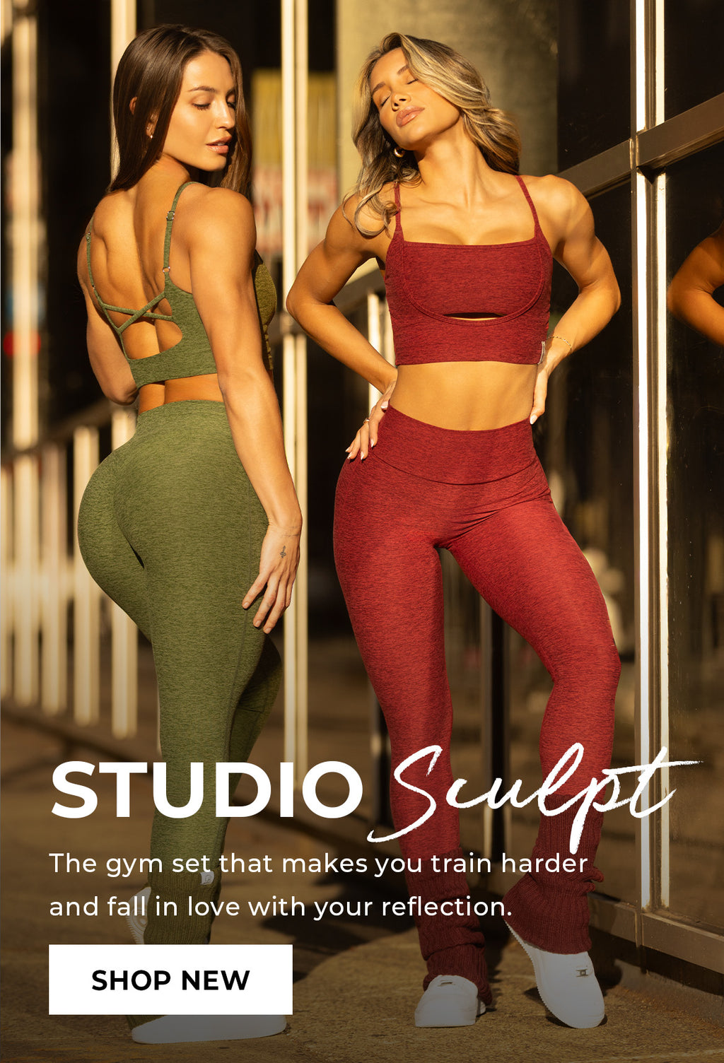 Two women in green and red gym sets standing in front of a mirror with 'Studio Sculpt' collection announcement. Text overlay reads 'The gym set that makes you train harder and fall in love with your reflection.' CTA 'SHOP NEW'