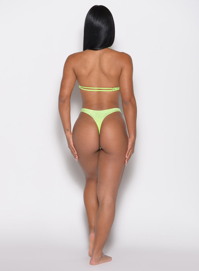 back profile of a back profile view of a model in our Sunkissed Sparkle Bikini Bottoms in Electric Lime color and the matching Sunkissed Sparkle Bikini Bra

