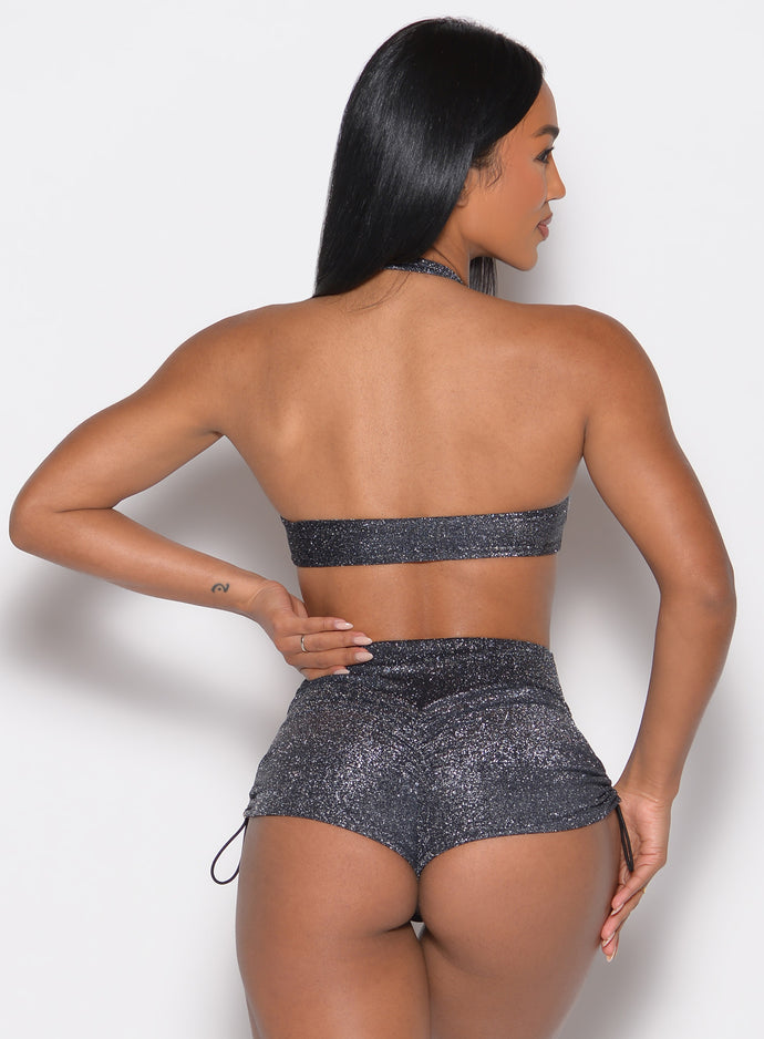 back profile view of a model with her left hand on her waist wearing the Sunkissed Sparkle Bikini Bra in Black Diamond color