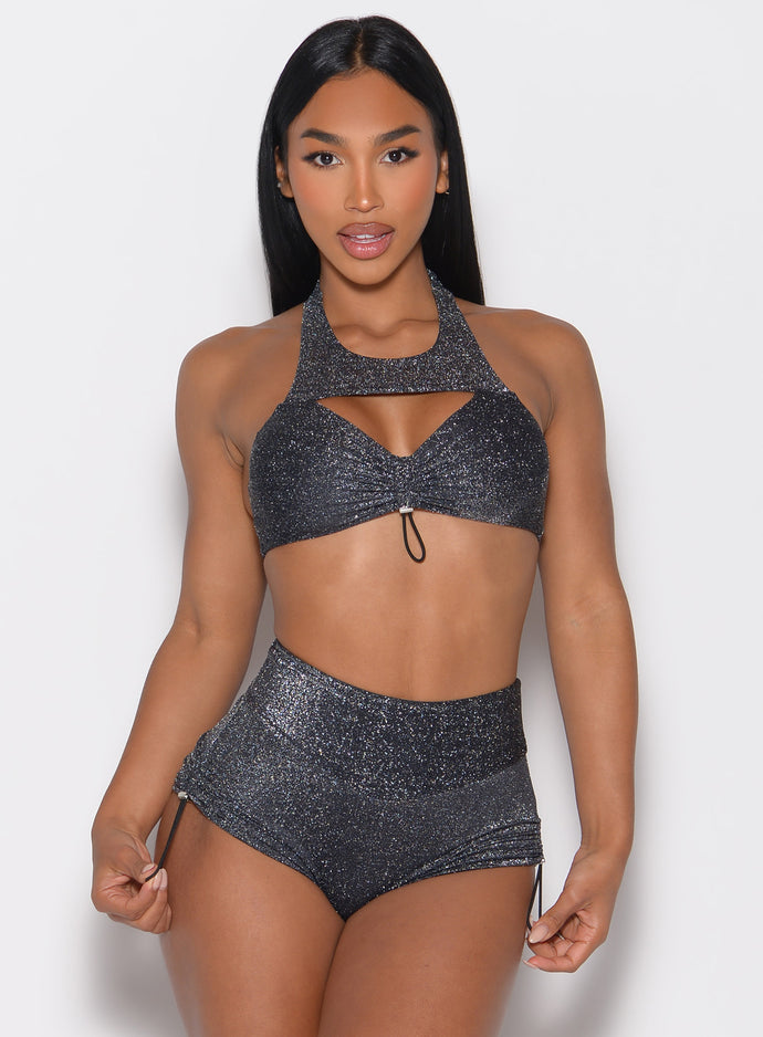 front profile view of a model holding the side string of the shorts wearing the Sunkissed Sparkle Bikini Bra in Black Diamond color