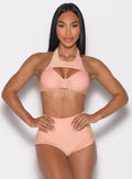 front profile view of a model with both hands on her waist wearing the Sunkissed Sparkle Bikini Bra in Golden Hour color paired with the matching shorts 