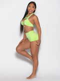left side profile view of a model looking to the left wearing the Sunkissed Sparkle Swim Shorts in Electric Lime color
