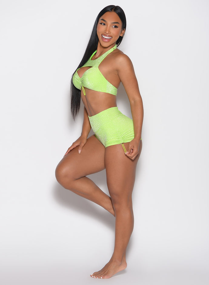 left side profile view of a model looking to the left wearing the Sunkissed Sparkle Swim Shorts in Electric Lime color