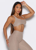 front right side profile view of a model with one hand resting on top of her head wearing the Super set bra in desert taupe color