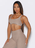 front profile view of a model wearing the Super set bra in desert taupe color paired with the matching leggings 