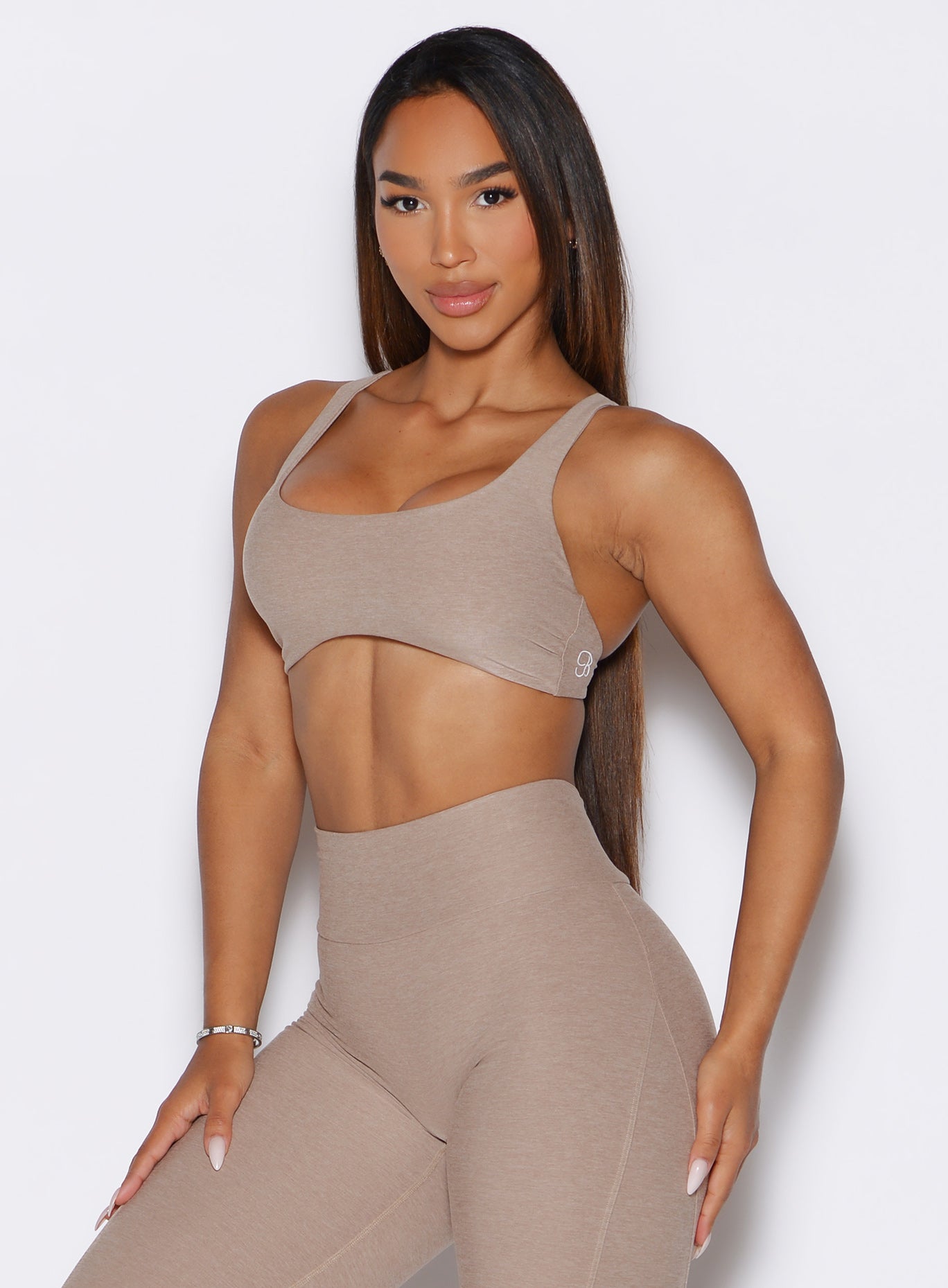 front profile view of a model wearing the Super set bra in desert taupe color paired with the matching leggings 