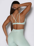 back side perspective of a model wearing the super set bra in soft aloe color