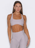 front profile view of a model with both hands on her thighs wearing the Super set bra in violet ice color