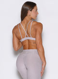 a rear view of a model facing to the right side wearing the Super set bra in violet ice color