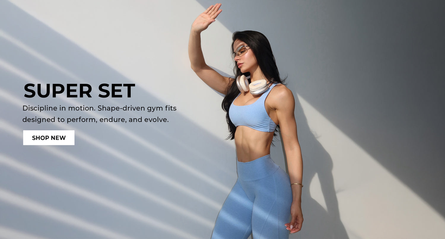 Woman in blue athletic wear with promotional text for 'Super Set' gym fits on a gray background. Text says "SUPER SET Discipline in motion. Shape-driven gym fits designed to perform, endure, and evolve. SHOP NEW"