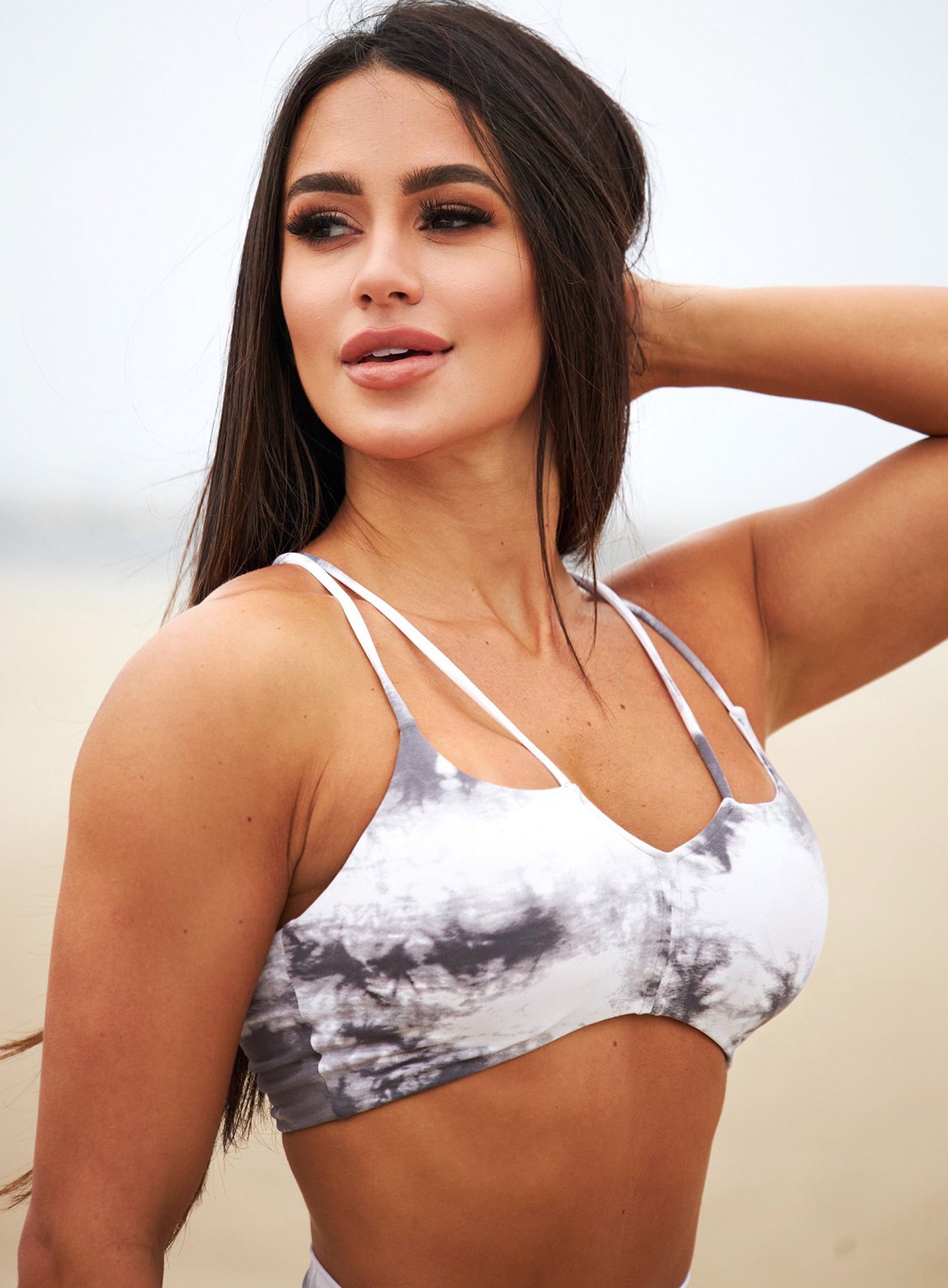 Zoomed in picture of a picture perfect model wearing our top notch bra in tie dye white gray 