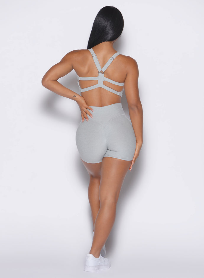 back view of a model wearing our tiny waist shorts in cloud color and the matching sports bra