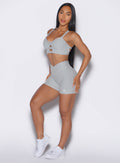 side left profile view of a model wearing our tiny waist shorts in cloud color and the matching sports bra