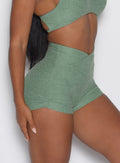 close up right side profile view of a model wearing the Tiny Waist Tie Shorts in basil color
