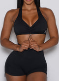 close up front view of a model adjusting the toggle in front wearing the Toggluxe Bra in black color
