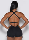 back profile view of a model with both hands on her waist wearing our Toggluxe Bra in black color