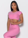 front profile view of a model holding the front toggle wearing the Toggluxe Tee in Bubblegum color
