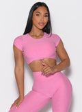 front profile view of a model with one hand on her thigh wearing the Toggluxe Tee in Bubblegum color