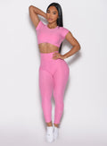 front profile view of a model with one hand on her waist wearing the Toggle Pull Leggings in Bubblegum color