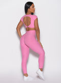 back right side profile view of a model wearing the Toggle Pull Leggings in Bubblegum color