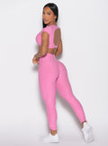 left side profile view of a model looking over her shoulder wearing the Toggle Pull Leggings in Bubblegum color