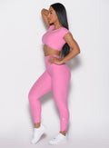 left side profile view of a model with one hand on her waist wearing the Toggle Pull Leggings in Bubblegum color
