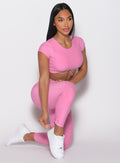 front right side profile view of a model in a kneeling pose wearing the Toggle Pull Leggings in Bubblegum color