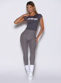 front view of a model wearing the Bombshell Era Tee in solid champion gray color  paired with the matching leggings