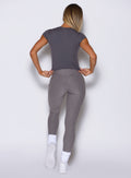 back profile view of a model wearing the Bombshell Era Tee in solid champion gray color paired with the matching leggings 