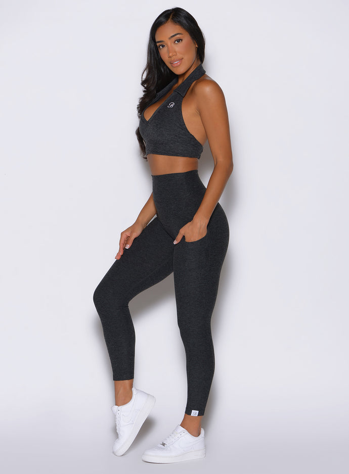left side profile view of a model wearing the Toned 7/8 Leggings in Charcoal color