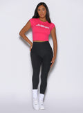 front profile view of a model with one hand on her waist wearing the Bombshell Era Tee in solid victory ruby color 