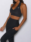 close up front view of a model wearing the Toned 7/8 Leggings in Charcoal color paired with the matching bra 
