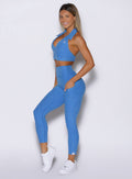 left side profile view of a model wearing the Toned 7/8 Leggings in Legacy Blue color