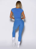 back profile view of a model wearing the Toned 7/8 Leggings in Legacy Blue color paired with the matching tee 
