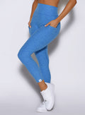 close up front left side view of a model wearing the Toned 7/8 Leggings in Legacy Blue color