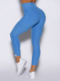 close up left side view of a model wearing the Toned 7/8 Leggings in Legacy Blue color