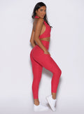 right side profile view of a model wearing the Toned 7/8 Leggings in Victory Ruby color