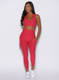 front view of a model looking to the left side wearing the Toned 7/8 Leggings in Victory Ruby color