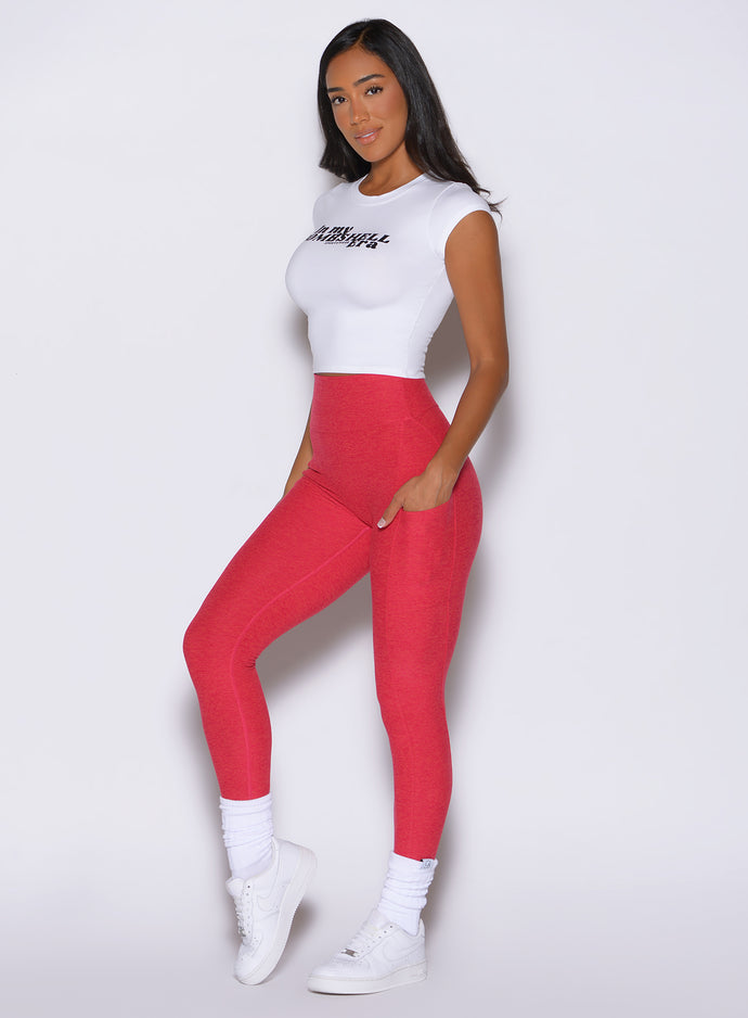 front left side view of a model wearing the Toned 7/8 Leggings in Victory Ruby color