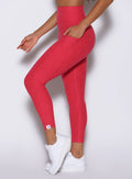 zoomed in left side view of a model wearing the Toned 7/8 Leggings in Victory Ruby color