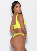 Right side view of a model facing to her right wearing our Tropical Tease Bikini Top in Neon Yellow color and the matching Tropical Tease Bikini Bottoms
