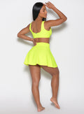 back profile view of a model wearing our Tropical Tease Skirt in Neon Yellow color and the matching Tropical Tease Bikini Top
