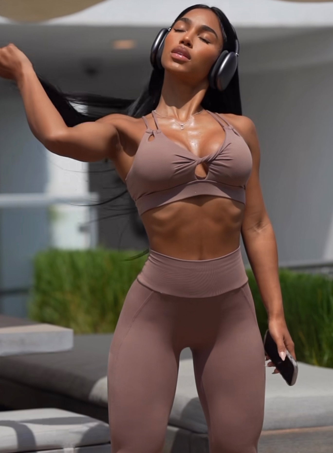 front view of female outside wearing the tan twist bra and shape leggings