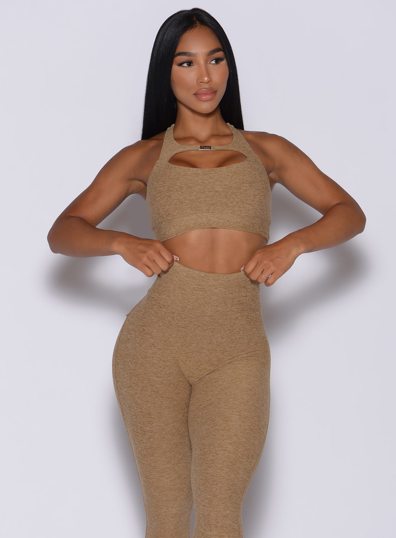 front  profile picture of a model wearing our two way sports bra in caramel color and a matching leggings