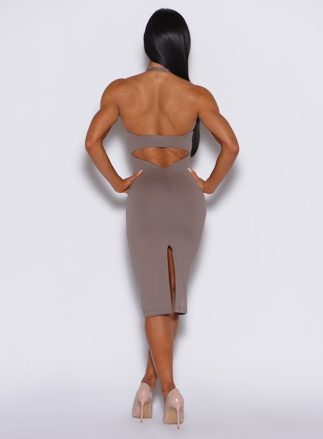 back profile view of a model with her hands on waist wearing our unforgettable dress in espresso color