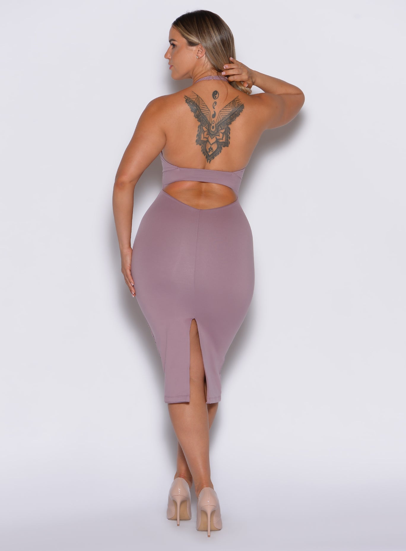 back profile view of a model wearing our unforgettable dress in light mauve color