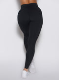 Close up back profile view of a model wearing our Uplift Peach Leggings in black color