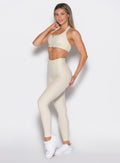 front left side profile view of a model wearing the Uplift peach leggings in pearl white color