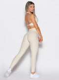 back right side profile view of a model wearing the Uplift peach leggings in pearl white color