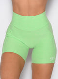 close up front view of a model wearing the Uplift Peach Shorts in Electric Green color